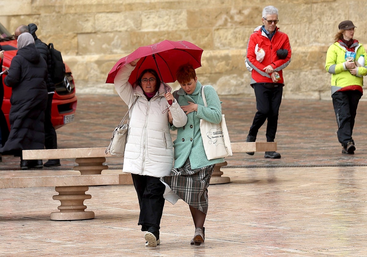 Dos mujeres bajo un paraguas en la Plaza del Triunfo de Córdoba