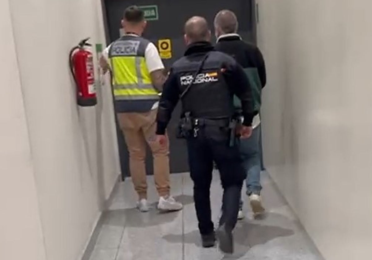 El fugitivo detenido en el aeropuerto de Alicante-Elche, custodiado por la Policía Nacional