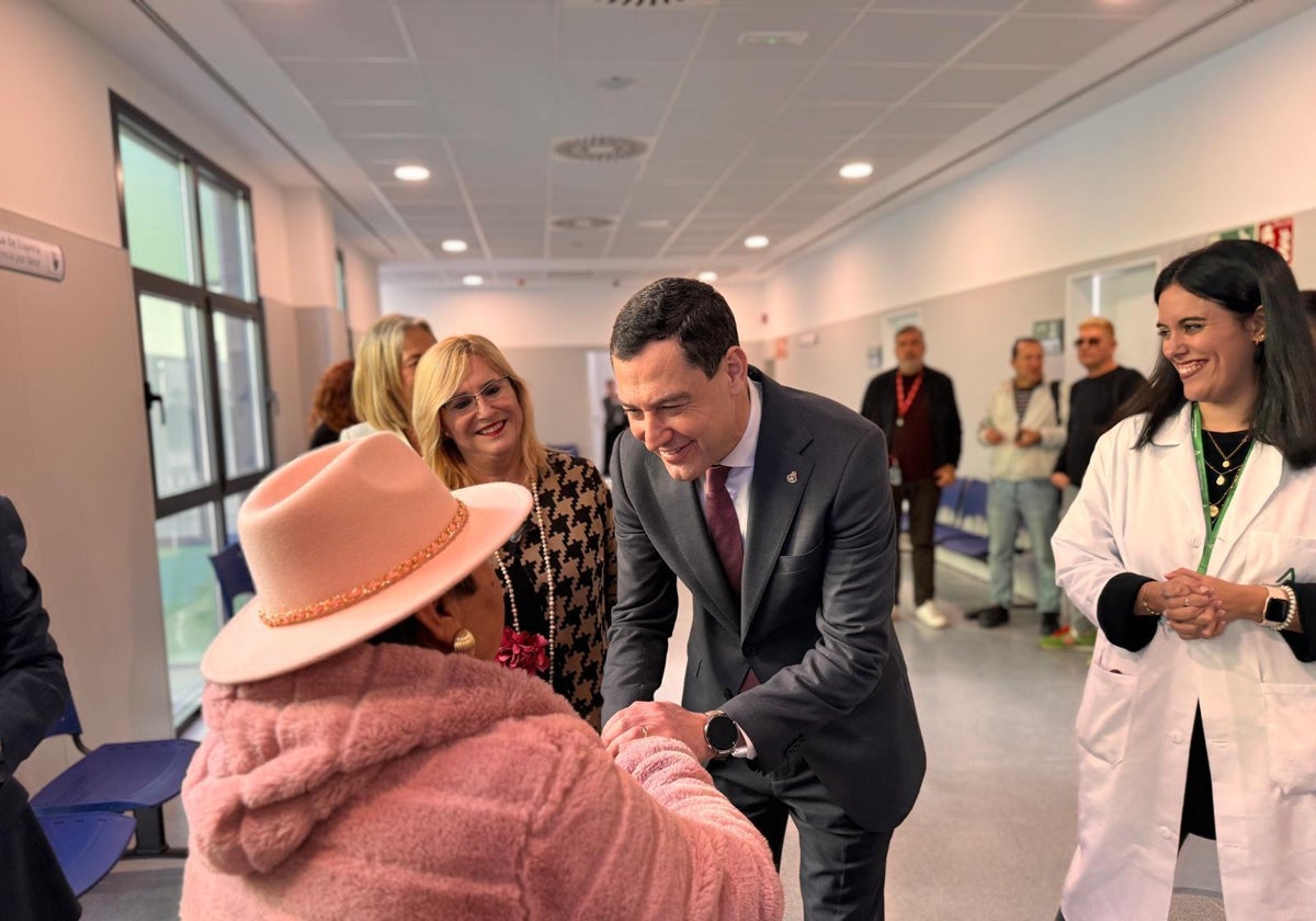 Juanma Moreno saluda a una señora durante la visita