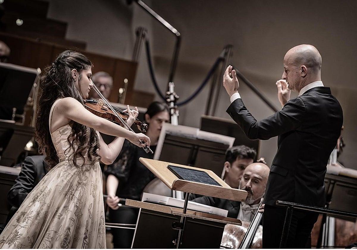 El director Guillermo García Calvo, la violinista Lana Zorjan y la Orquesta de Valencia, durante su concierto en el Palau