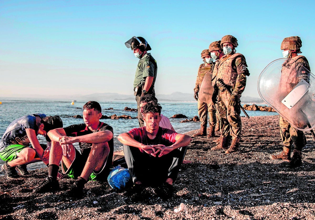 Soldados españoles, en la playa ceutí del Tarajal, vigilando a inmigrantes