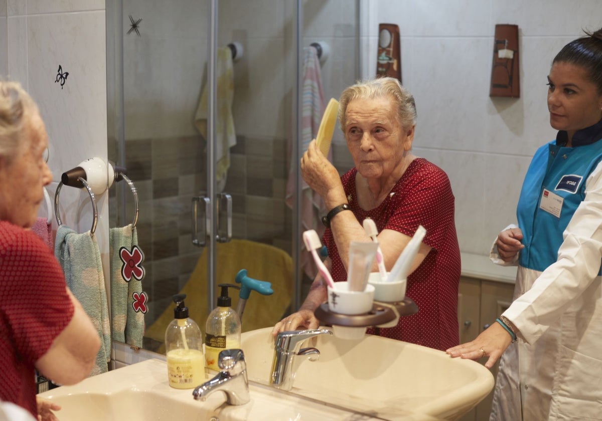Una persona mayor, con la cuidadora a domicilio que la ayuda en el día a día