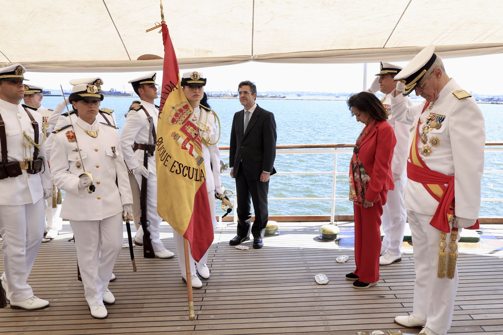 La Princesa Leonor, con la bandera de España en la mano, en la cubierta del barco junto a la ministra de Defensa.