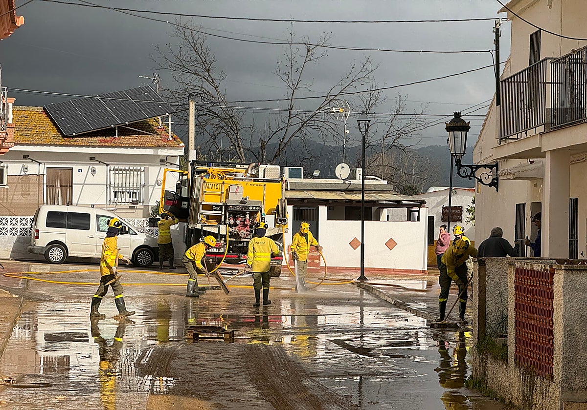 Un retén del Infoca limpiando las calles en la barriada de Doña Ana en Cártama