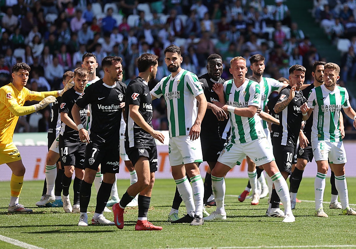 Los jugadores defienden un saque de esquina durante el partido
