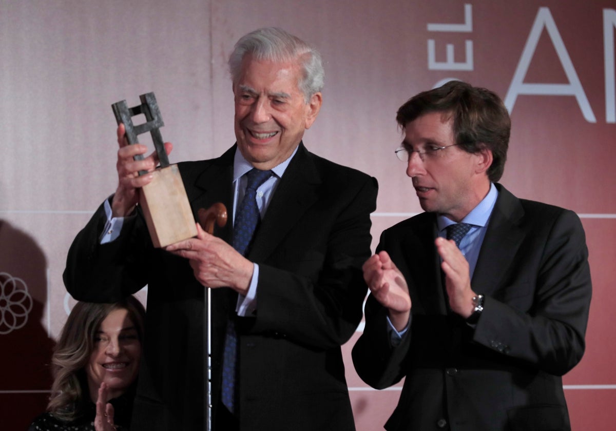 El escritor Mario Vargas Llosa, acompañado por el alcalde de Madrid, José Luis Martínez-Almeida, mientras recibe el premio 'Madrileño del Año', en 2022