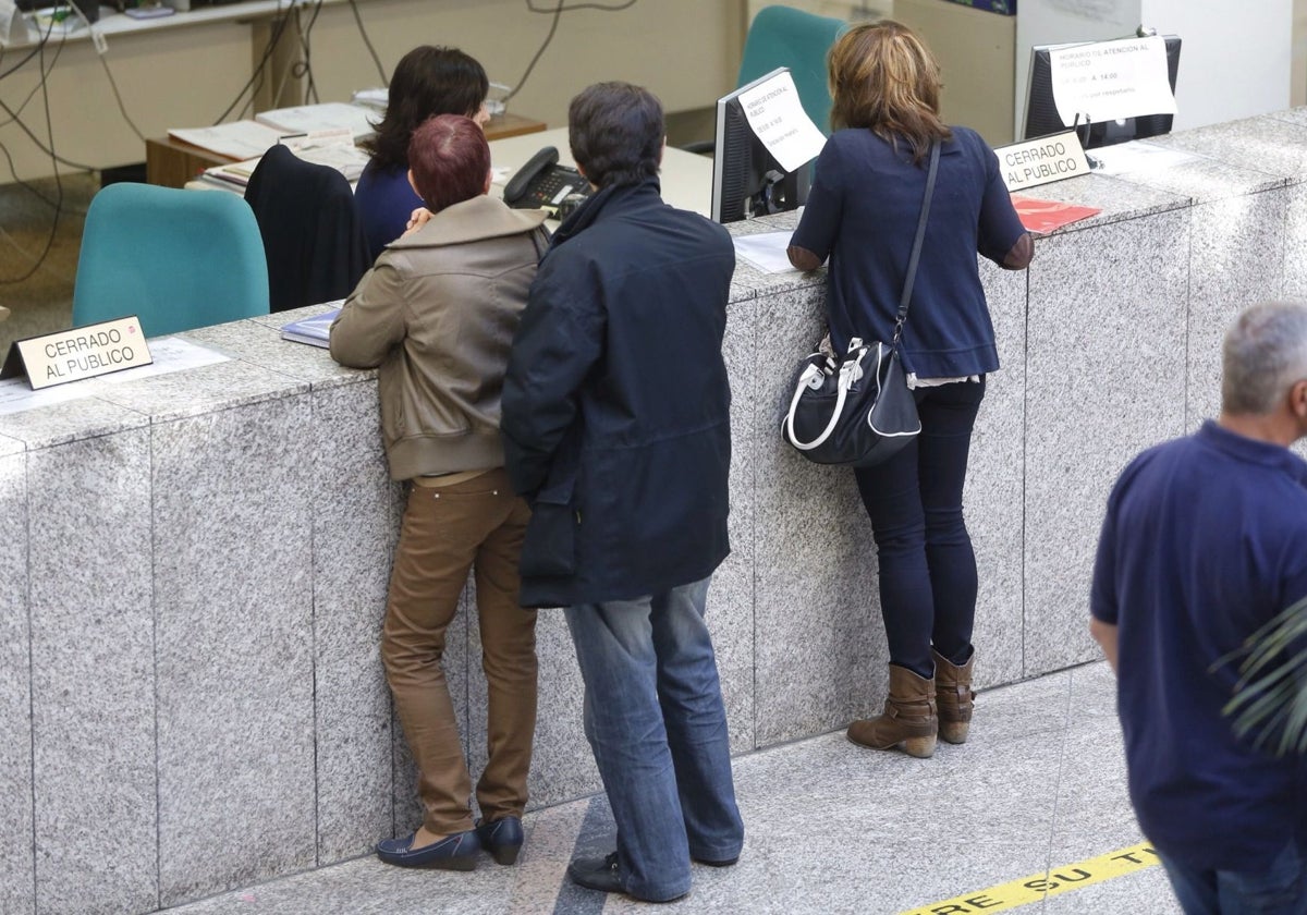 Funcionarios atienden a varios ciudadanos en una imagen de archivo