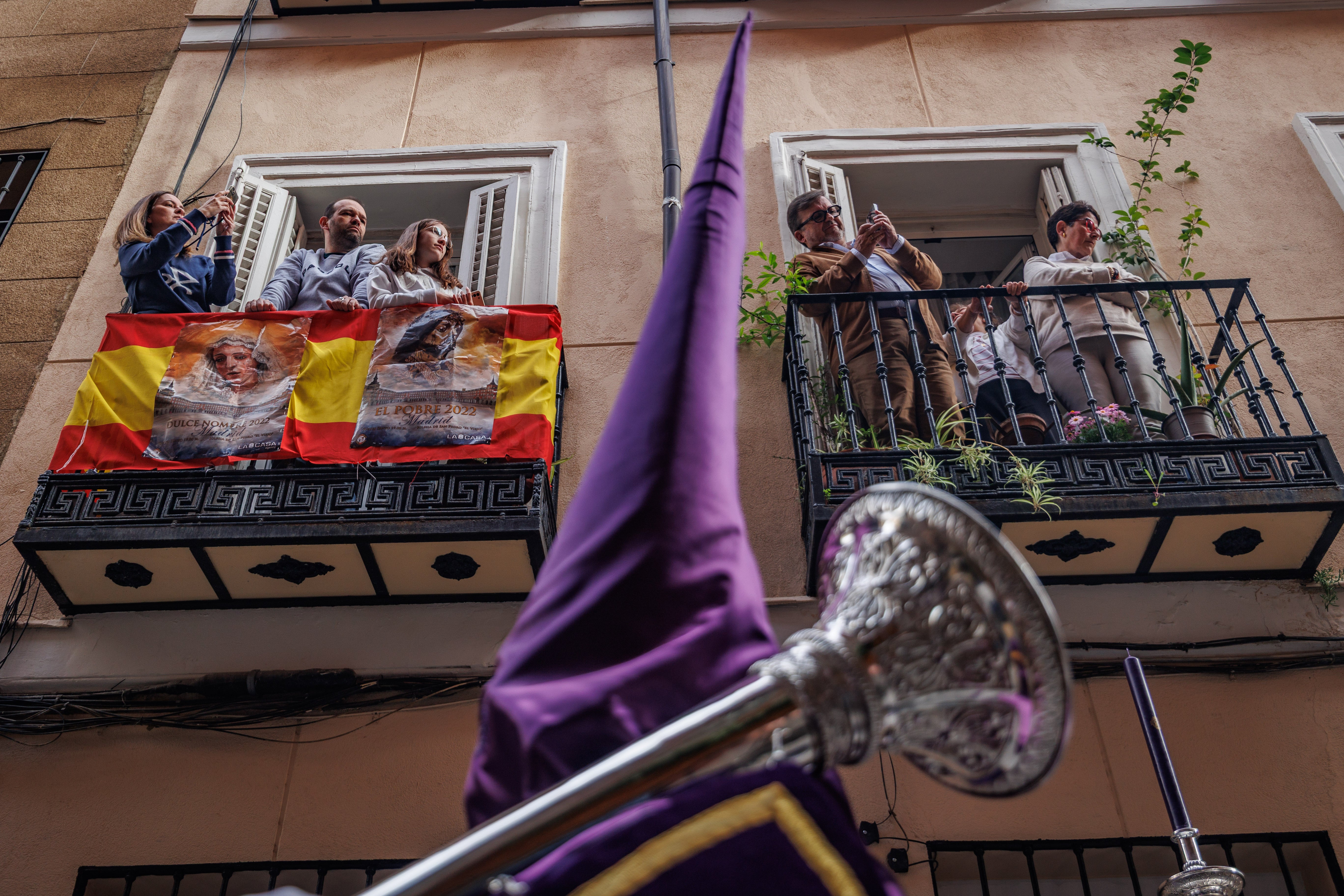 Los vecinos observan desde sus balcones procesionar a los nazarenos y siguen la Semana Santa madrileña con devoción