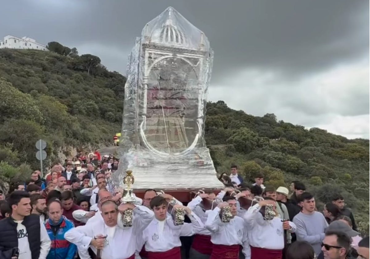 Primeros compases de la bajada con las andas de la Virgen de Araceli protegidas por el riesgo de lluvia