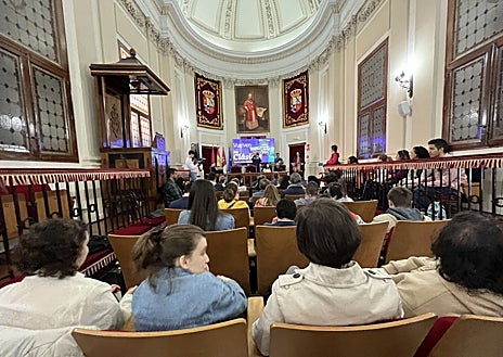 Imagen secundaria 1 - En la imagen superior, algunos de los jóvenes que han participado en la lectura de la novela de Miguel Cervantes. Abajo, el acto se celebró en el salón Lorenzana de la UCLM. A la derecha, una de las participantes lee 'El Quijote'