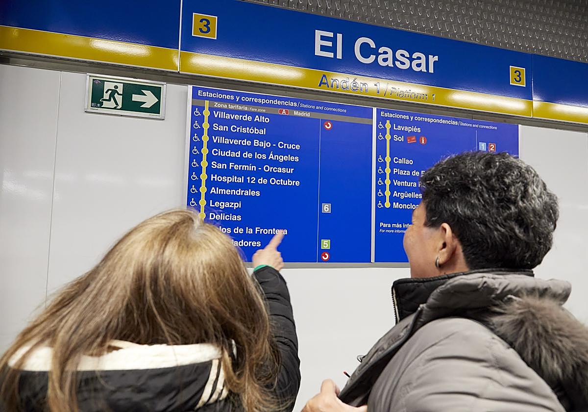 Dos mujeres miran el listado de estaciones de la Línea 3, en El Casar, en el día de la ampliación del recorrido.