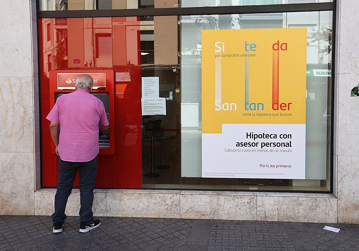 Un hombre saca dinero en una oficina de un banco en Córdoba