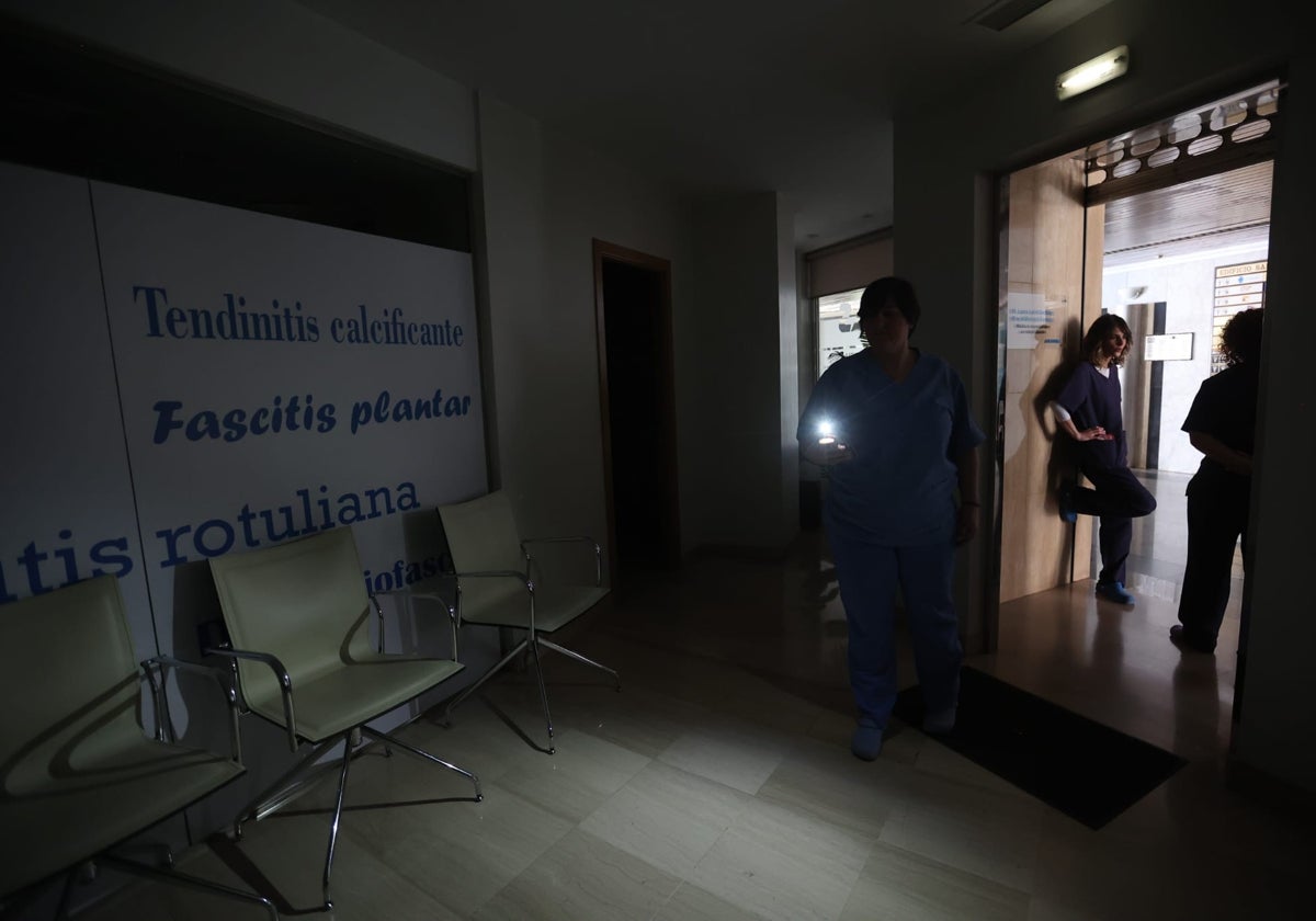 Una trabajadora de una clínica se abre paso en el local con una linterna