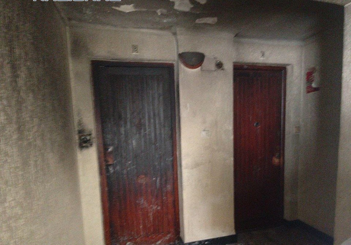 Daños causados por el incendio en la vivienda, visibles en la puerta exterior principal