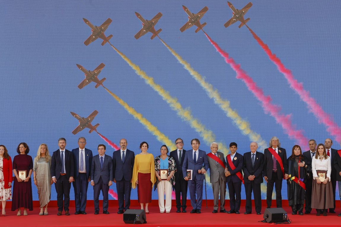 La presidenta de la Comunidad de Madrid, Isabel Díaz Ayuso; el alcalde de Madrid, José Luis Martínez-Almeida; el presidente de la Asamblea de Madrid, Enrique Ossorio Y el presidente del Senado Pedro Rollán, entre otras personalidades junto a algunos de los galardonados con las Grandes Cruces de la Orden del Dos de Mayo como el economista Pedro Schwartz, el campeón de MotoGP Jorge Martín, la cantante Massiel y el cantaor José Mercé.