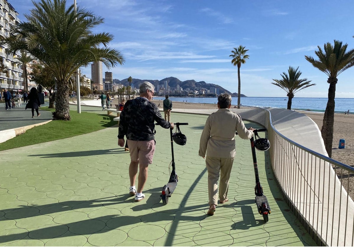 Turistas con patinetes eléctricos en el paseo de la Playa de Poniente de Benidorm, que ha recuperado la bandera azul
