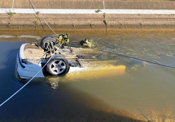 Bomberos rescatando el coche hundido en un canal de Cartaya