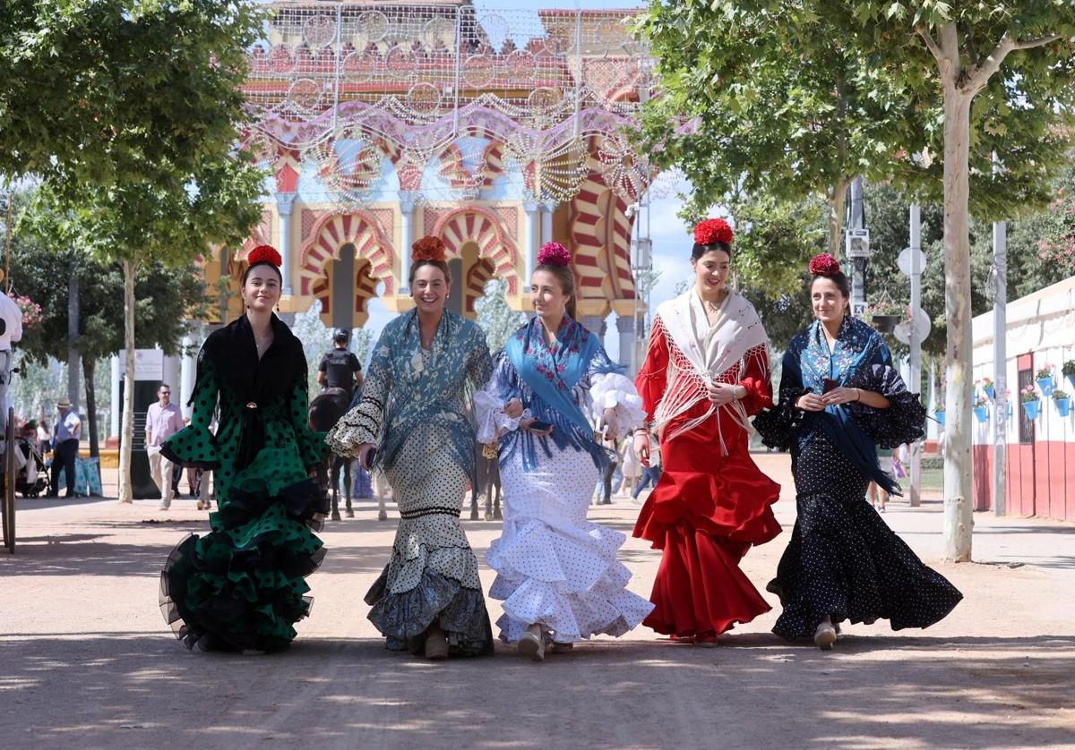 Un grupo de chicas vestidas de gitana caminando por El Arenal