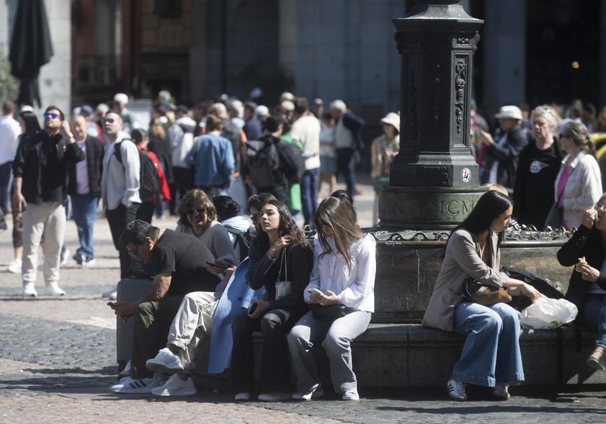 Madrileños y turistas en la Plaza Mayor