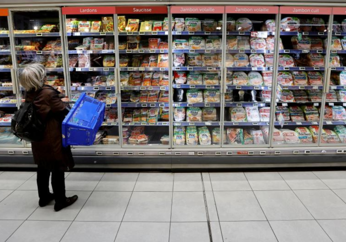 Una mujer compra en un supermercado en foto de archivo