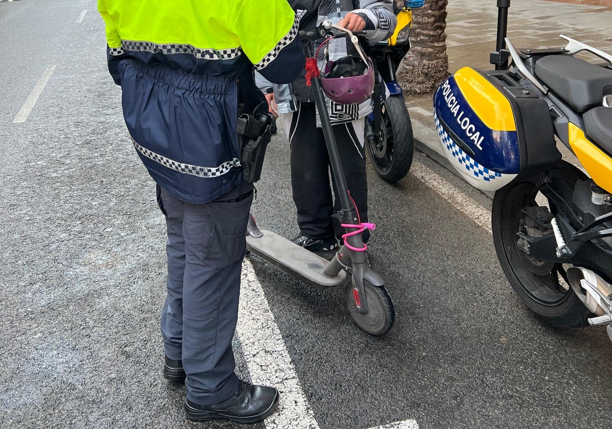 Un policía local de Alicante realiza un control a un usuario de patinete eléctrico