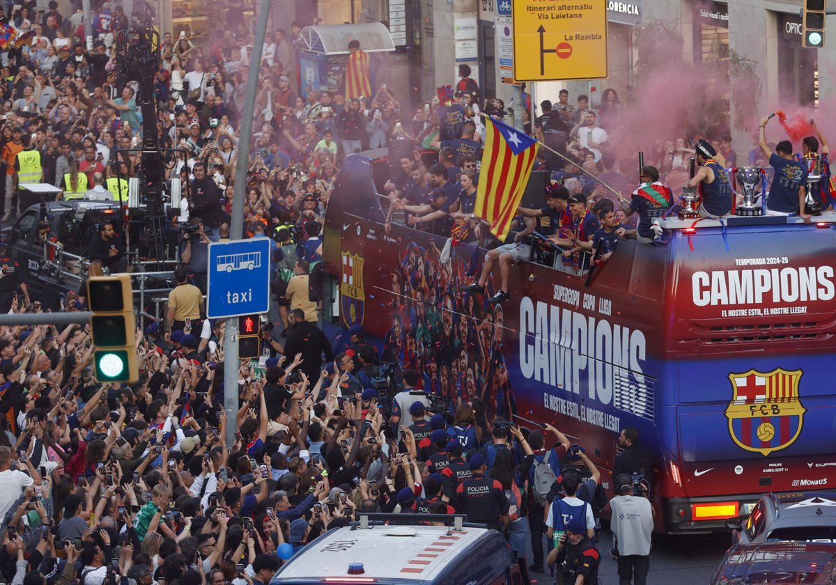 Autobús del Barça, ayer, con Íñigo Martínez exhibiendo la bandera 'estelada' en un momento de la rúa por las calles de la capital catalana