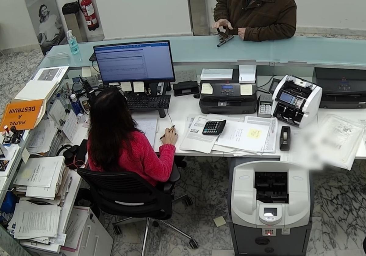 Cámaras de seguridad del banco captan como el detenido amenaza con una pistola a la trabajadora