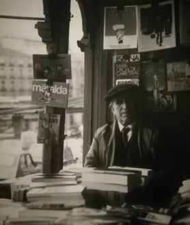 Imagen secundaria 2 - En la imagen superior, Efrén, de la caseta número 8 de la Cuesta de Moyano, en sus inicios en la feria. Aterrizó allí por su suegro. Abajo, a la izquierda, Un joven Fernando Plaza posa junto a su caseta. A sus 80 años, sigue acudiendo cada día al lugar que, a estas alturas, considera su vida. A la derecha, Ángel Méndez, el primer librero de la familia que llegó a la Cuesta en 1946 tras años entre historias en papel