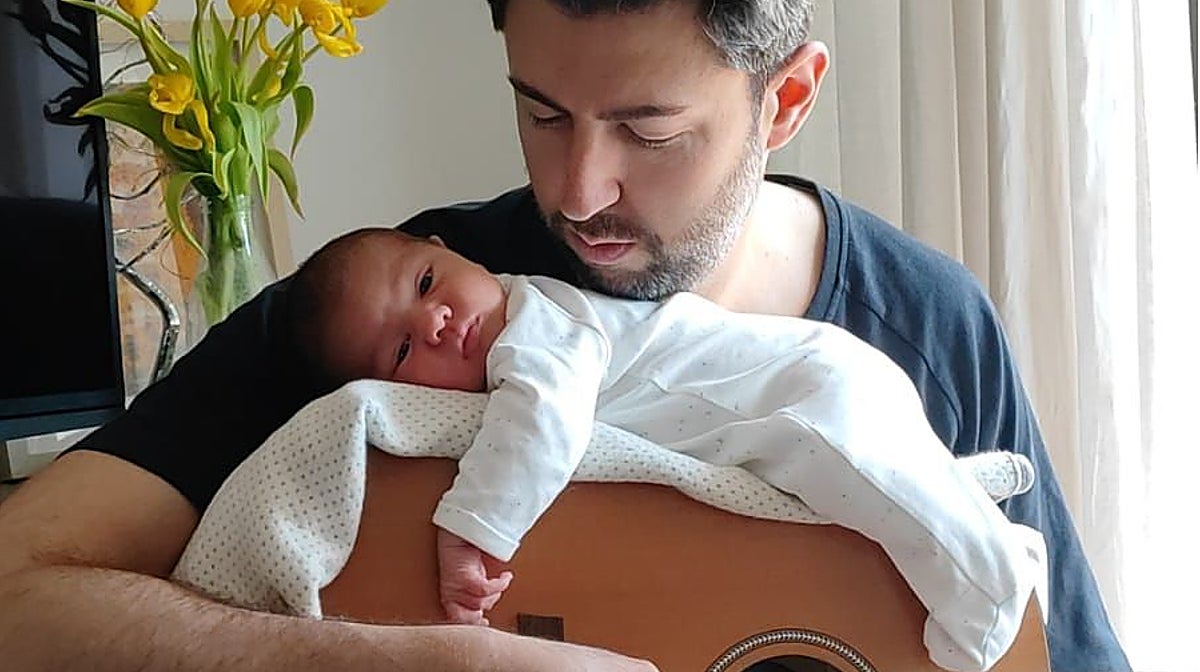 El pequeño Pablo, con 17 días de vida, dormita sobre la guitarra de su padre