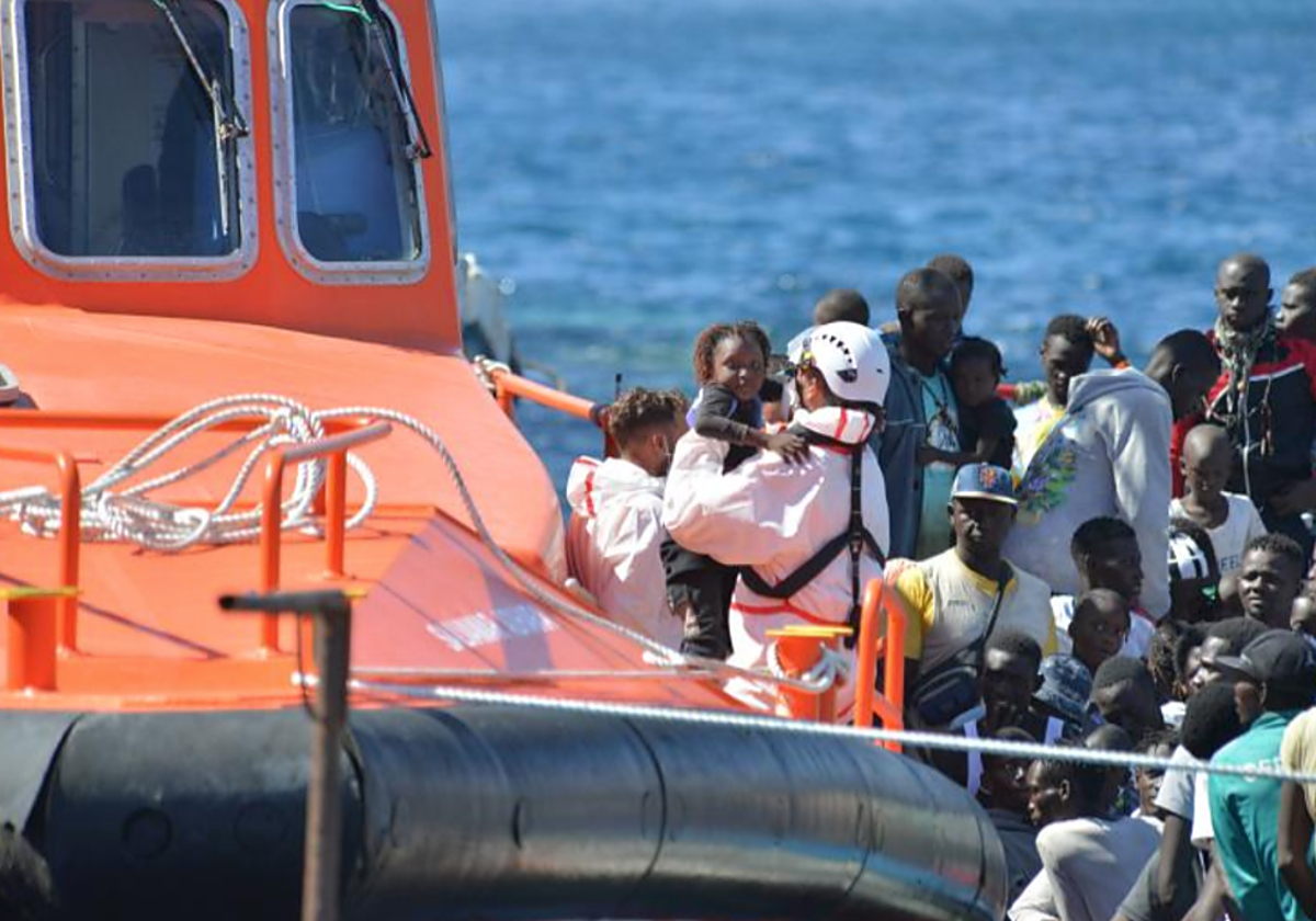 Un rescatador coge en brazos a una bebé mientras se organiza el desembarco de la Salvamar en La Restinga, El Hierro