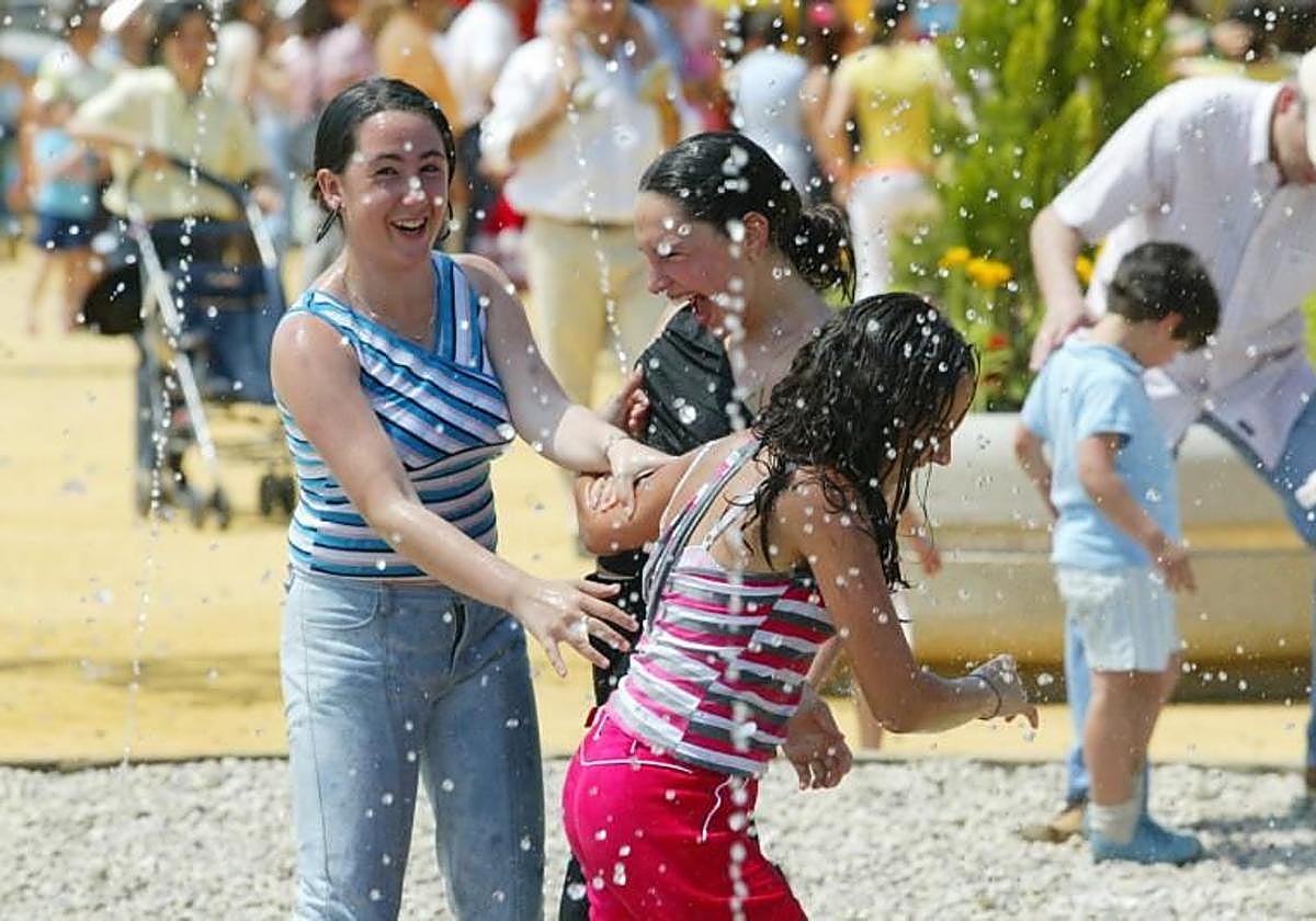 Unas jóvenes se refrescan en una fuente del real
