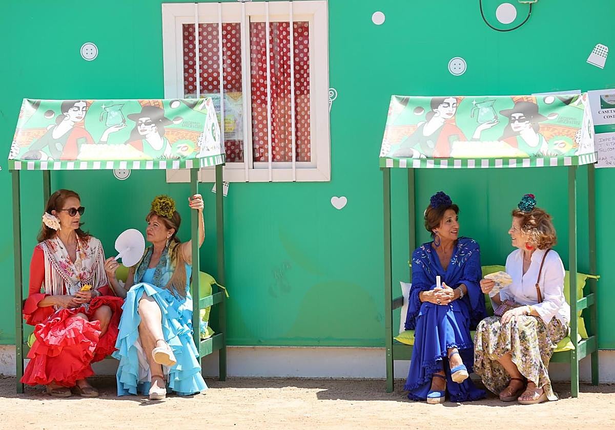 Cuatro mujeres se protegen del sol en la Feria