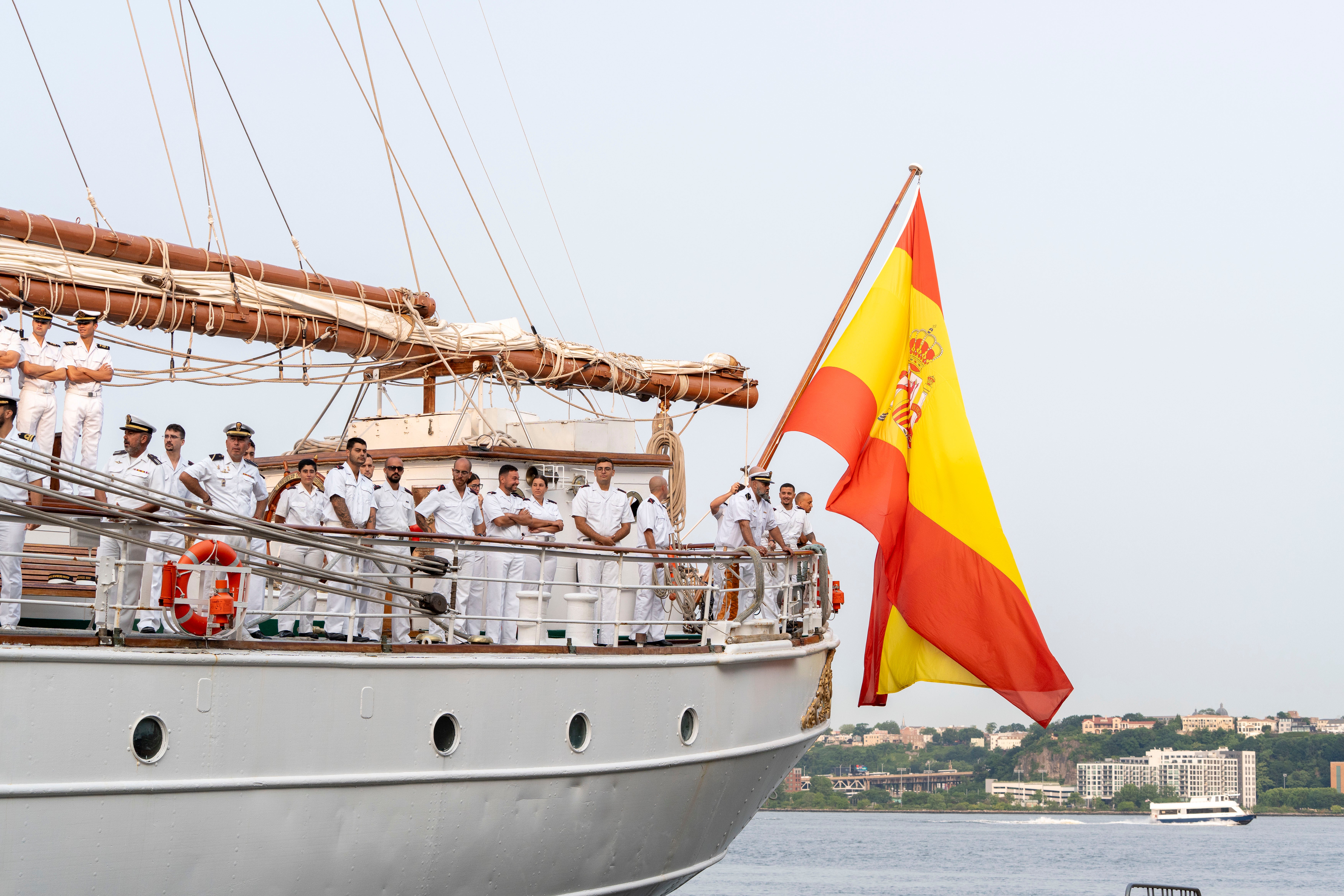 Los guardamarinas, junto a la bandera española que luce en el Elcano.