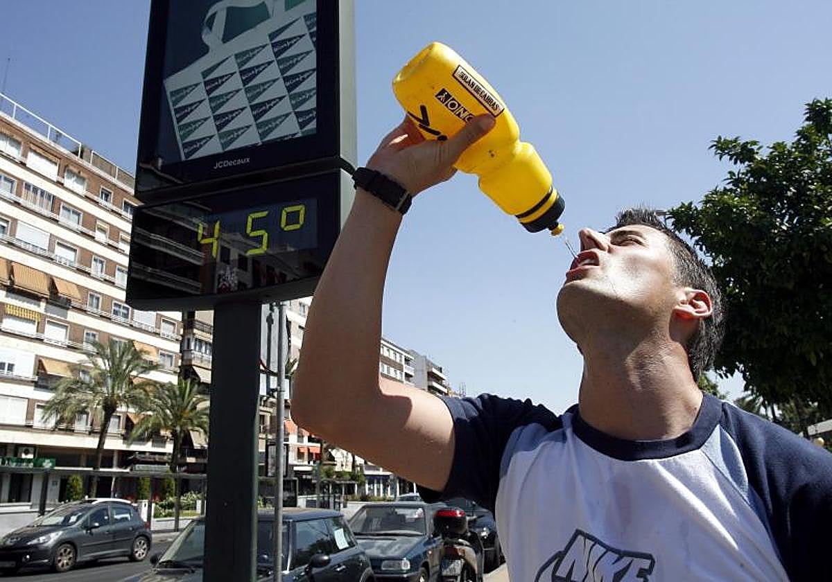 Un joven se refresca en una jornada de calor abrasador en Córdoba