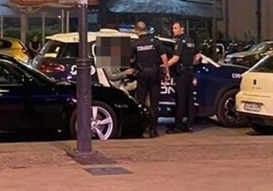 El directdor es introducido en un coche de la Policía Nacional