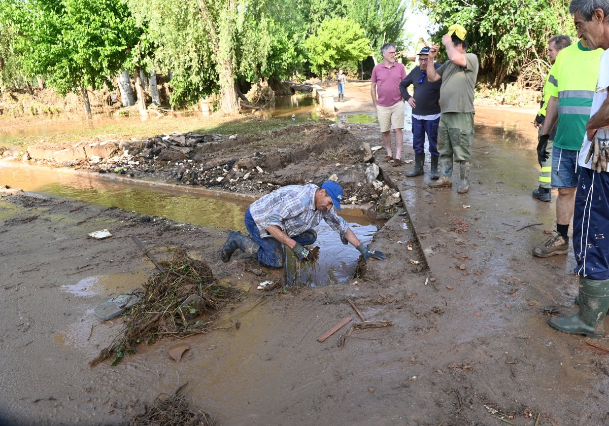 Vecinos de Azuara limpiando la maleza y el barro que arrastró la fuerte tromba de agua