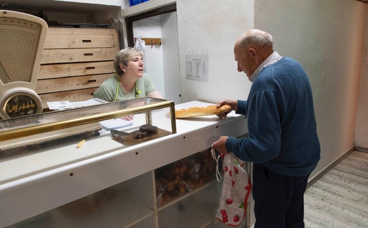 Imagen principal - Arriba, Consuelo Guillén despacha pan en su negocio de Burbáguena (Teruel). Abajo, Jesús en ruta a Cucalón y Lanzuela