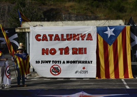 Imagen secundaria 1 - La protesta de la ANC contra la visita de los Reyes a Montserrat ha congregado a unas decenas de personas (arriba), lejos del músculo exhibido en los años álgidos del 'procés'. Sobre estas líneas, una de las pancartas contra Felipe VI. A la derecha, manifestantes con banderas
'estelades' a las espaldas. 