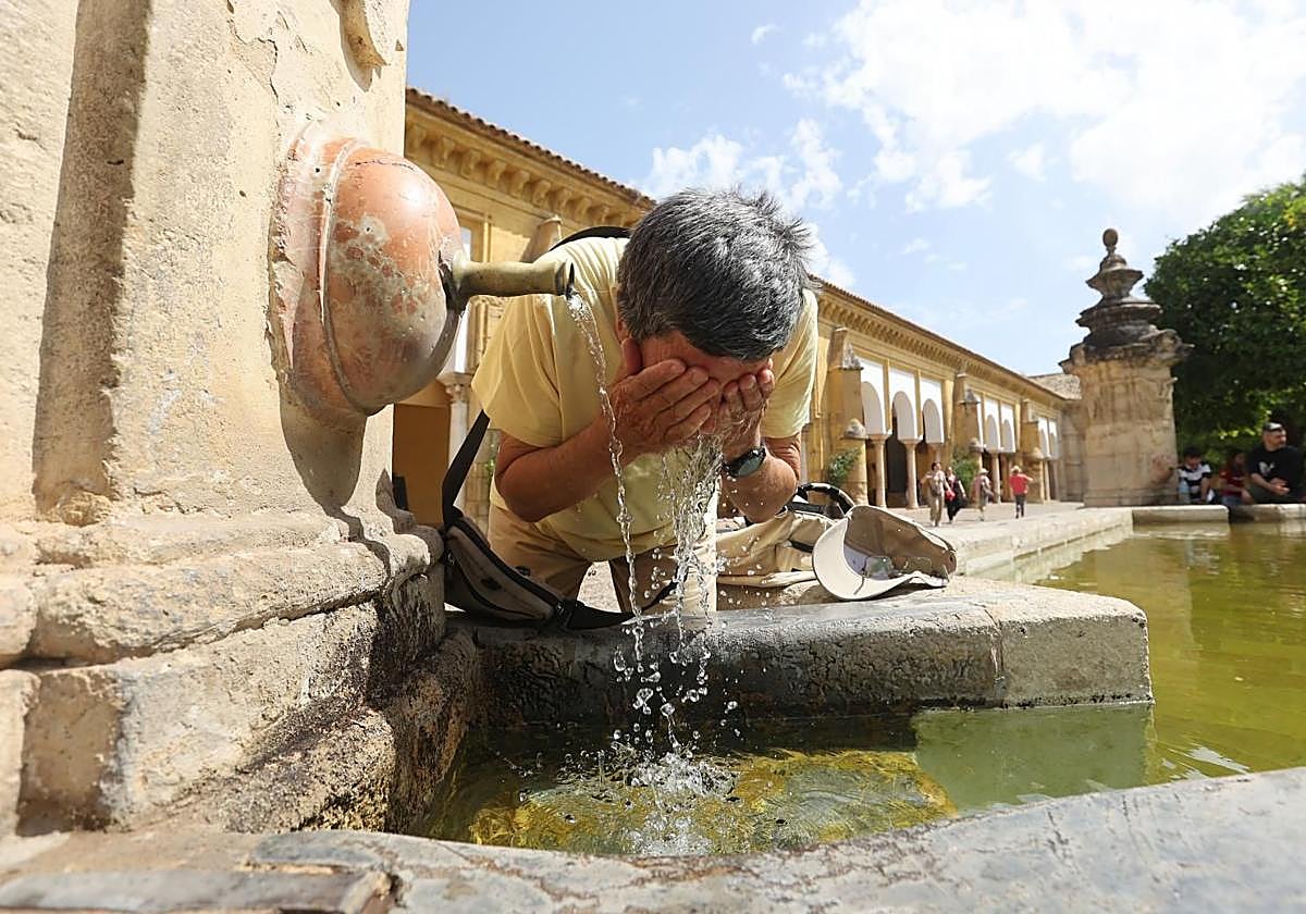 Un hombre se refresca en una fuente del Patio de los Naranjos de Córdoba
