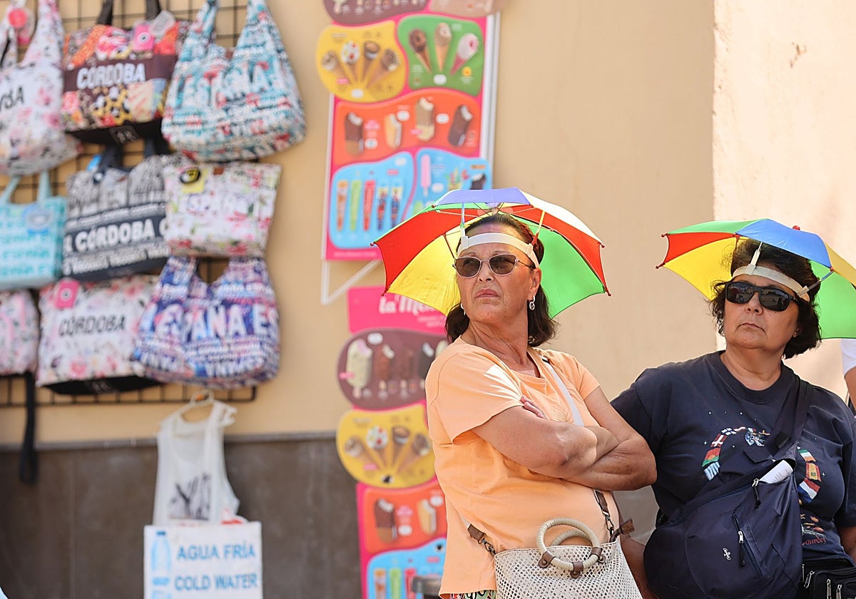 Dos personas se protegen del calor junto a la Mezquita-Catedral de Córdoba