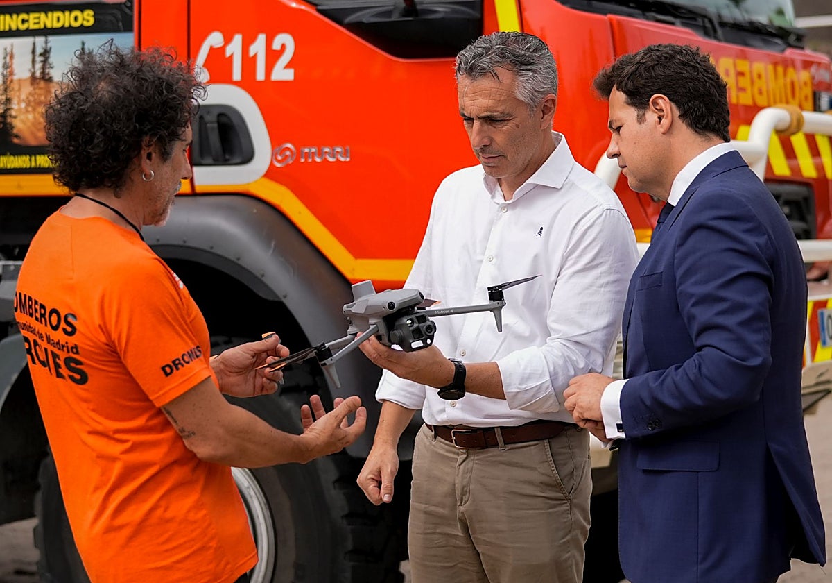 El consejero Novillo, junto al alcalde de las Rozas, José de la Uz, y uno de los bomberos de la Comunidad, con uno de los drones que se utilizan para vigilancia y extinción
