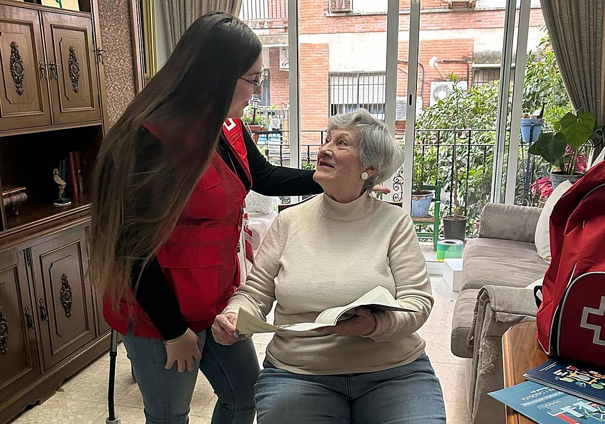 Una voluntaria de Cruz Roja en casa de una señora en su vivienda de Córdoba