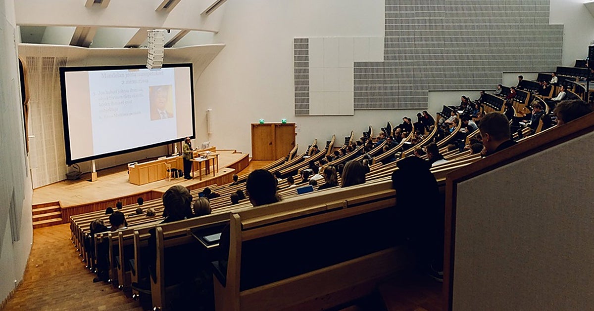 Un profesor imparte clases en un aula universitaria