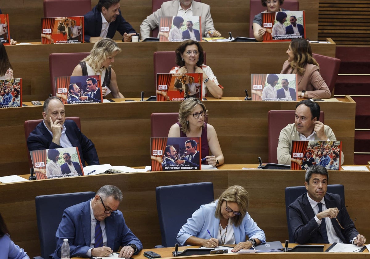 Imagen de los diputados del PP, este jueves, con los carteles contra el PSOE en las Cortes Valencianas