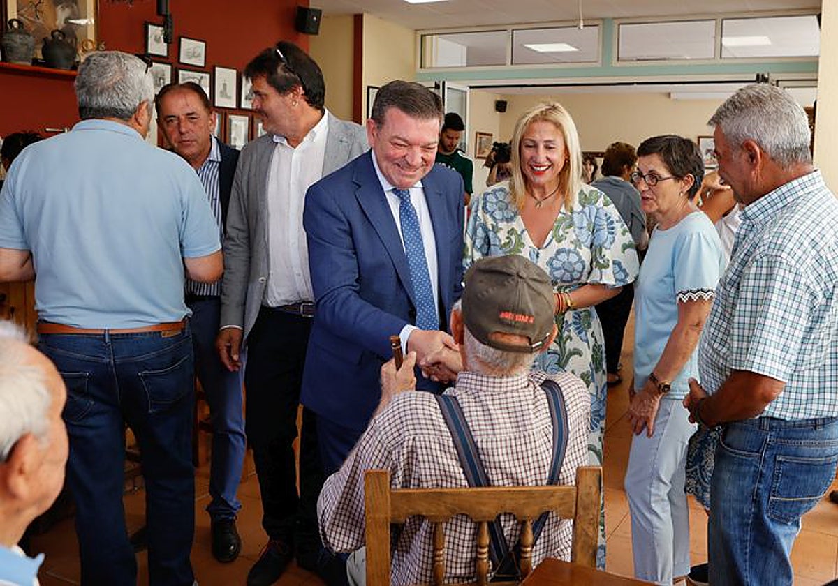 El consejero de la Presidencia saluda a un vecino de Cubo de la Solana (Soria) en el bar del pueblo