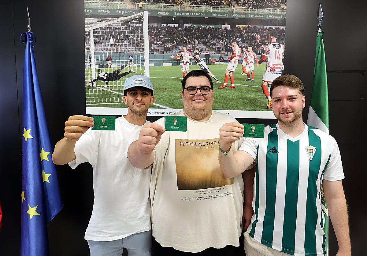 Tres aficionados del Córdoba CF con sus carnés de abonados