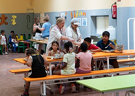 Imagen secundaria 1 - Arriba, Mª Carmen Marcos, junto a la jefa de estudios, Amparo Jiménez. Abajo, izquierda, el comedor con los niños y a la derecha, una de las madres de origen extranjero que componen el proyecto Hilvana