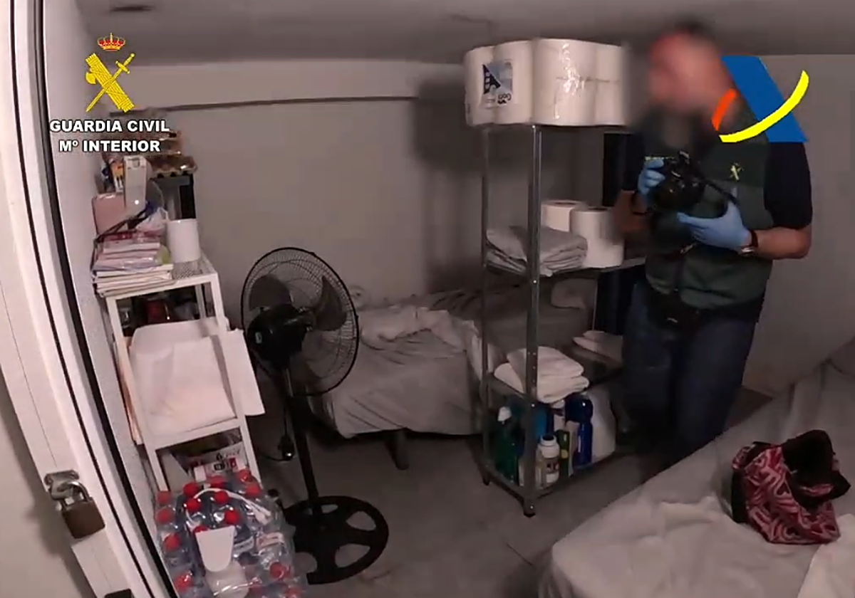 Un agente de la Guardia Civil examina los habitáculos donde dormían las víctimas