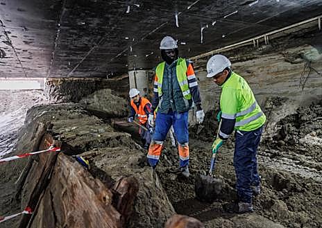Imagen secundaria 1 - En las dos primeras imágenes, los operarios descubren los restos del canal del Manzanares; en la tercera fotografía, la jaula ya construida y el carril para desplazar las losas sin dañarlas