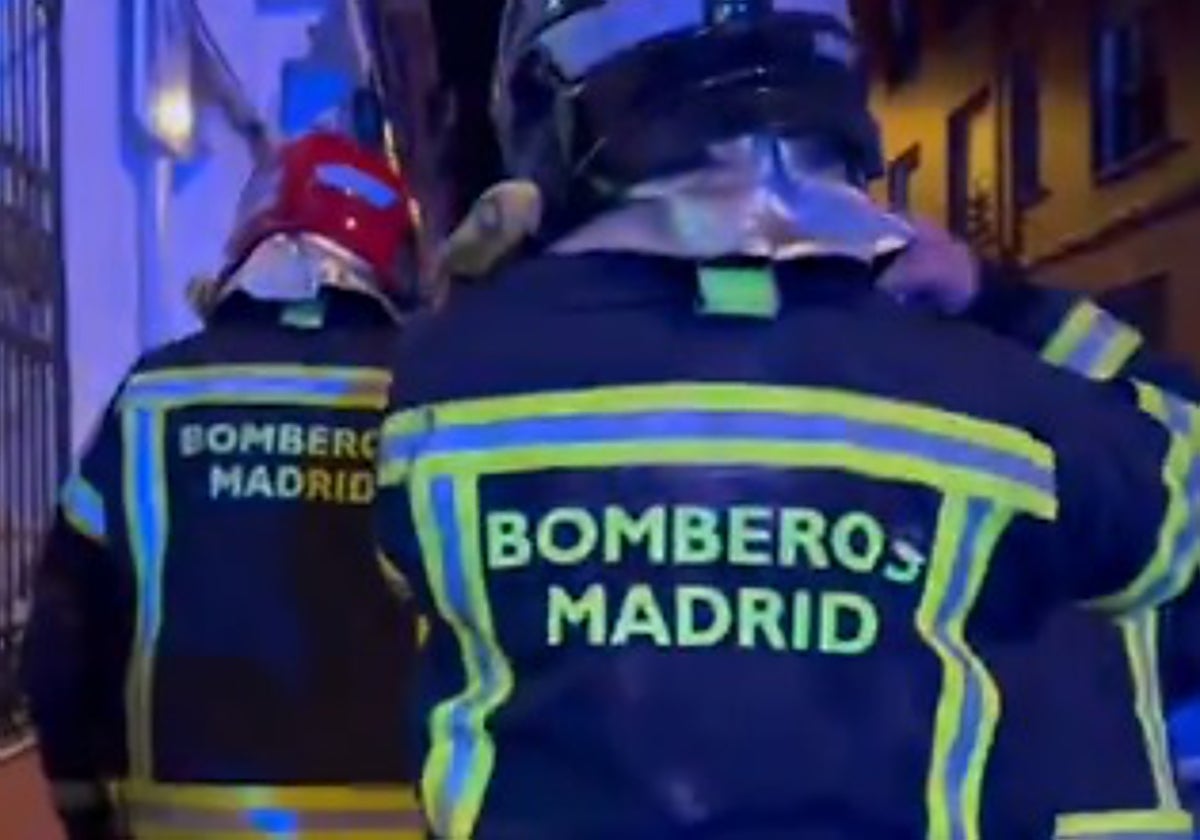 Dos bomberos trabajando en la extinción del incendio de Puente de Vallecas